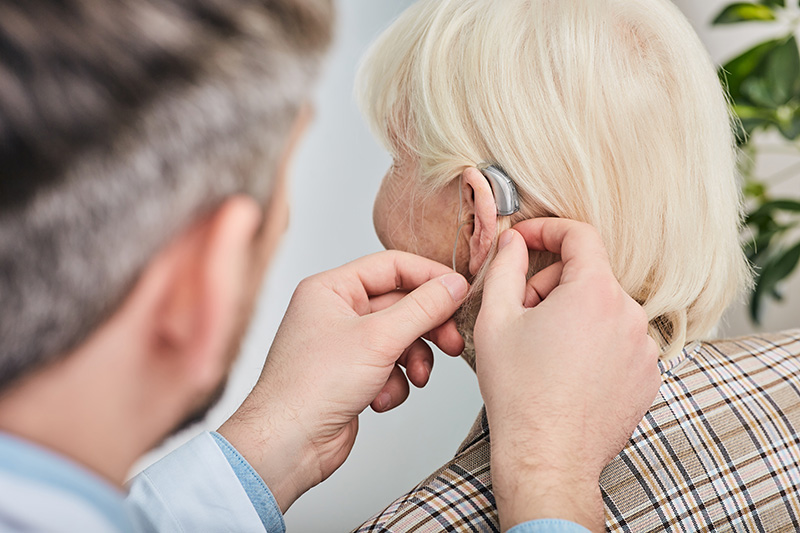 a Colorado Ear Care audiologist fitting custom hearing aids