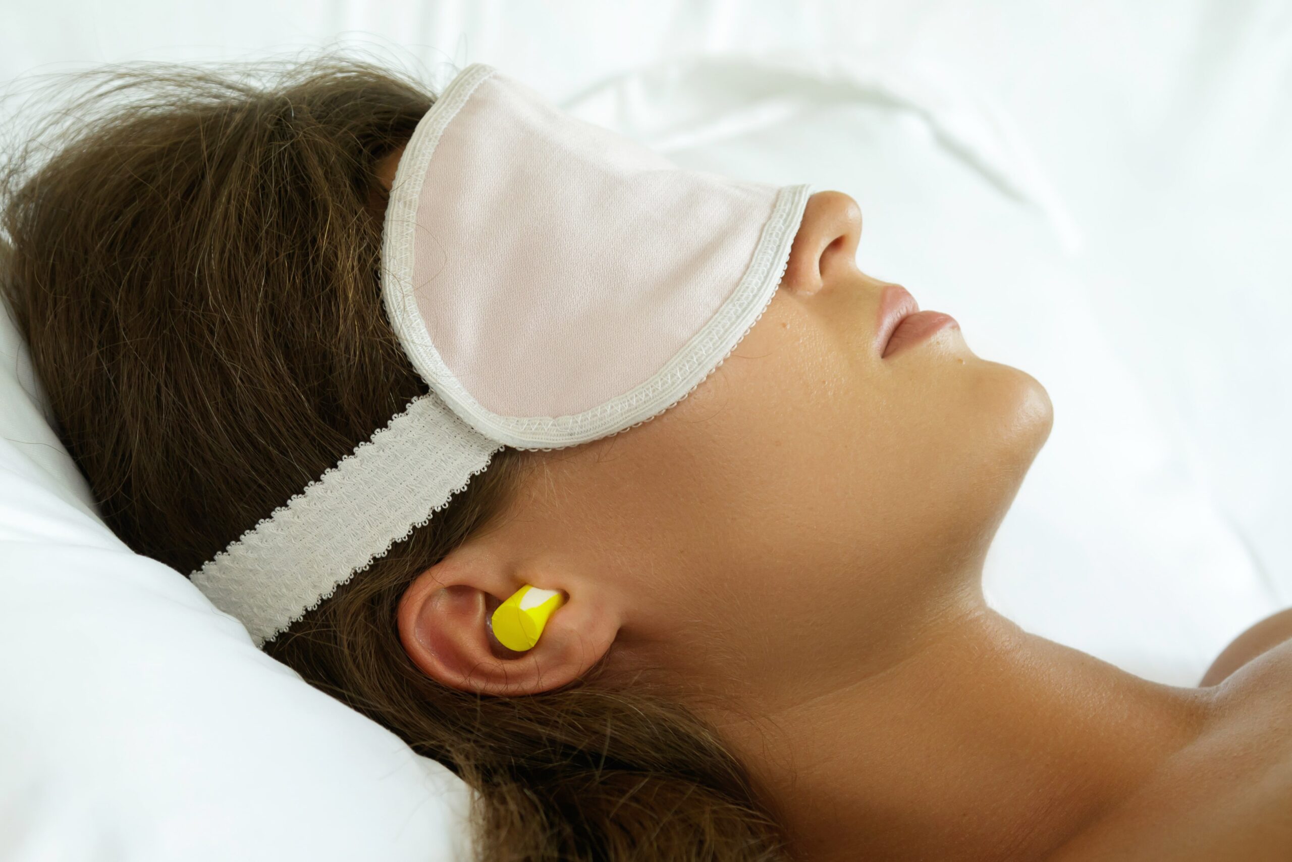 Lady sleeping with ear plugs.