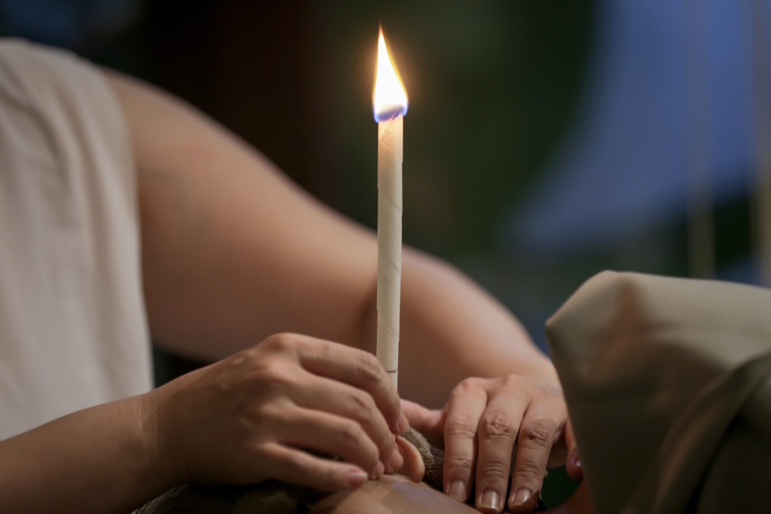 Woman getting ear candle treatment.