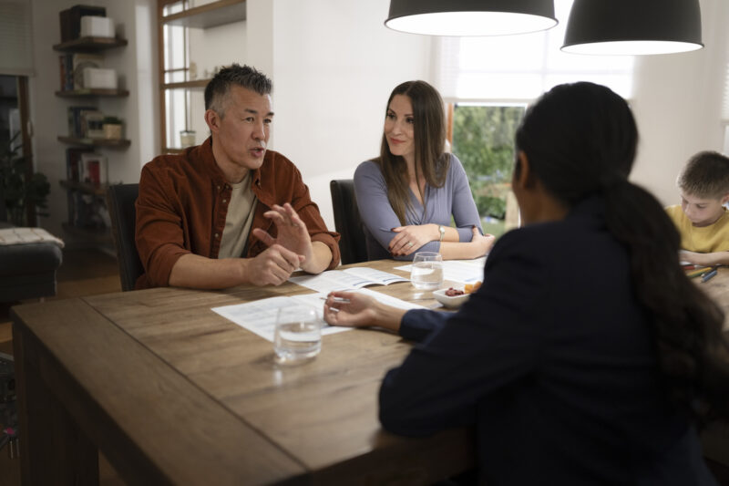 A family discussing hearing aid options at a table, emphasizing communication and support.