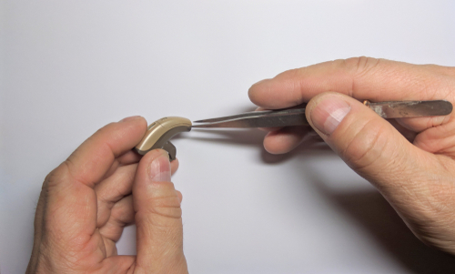 Person repairing hearing aids.